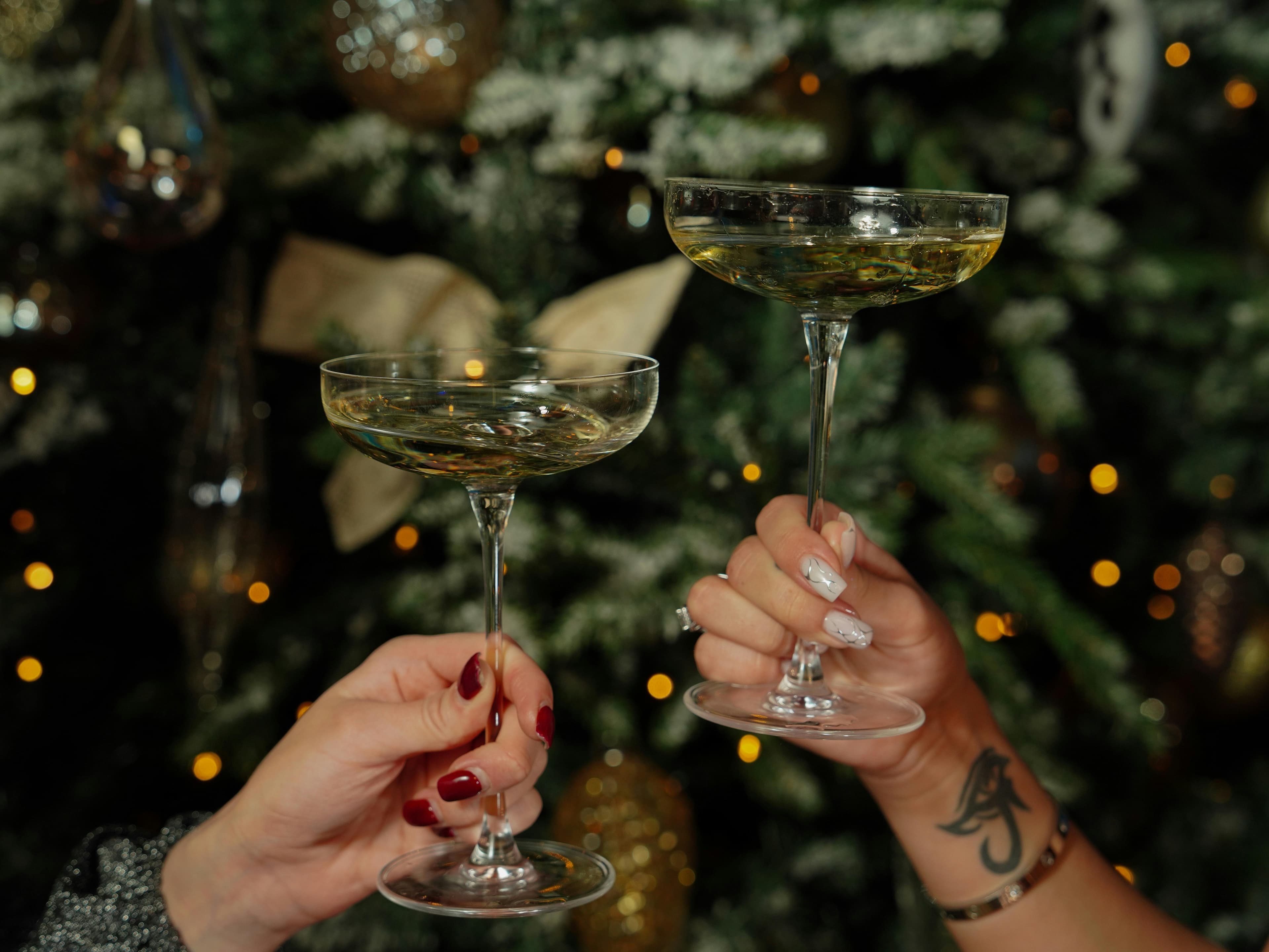Holiday Events - women holding cocktails on the background of a christmas tree