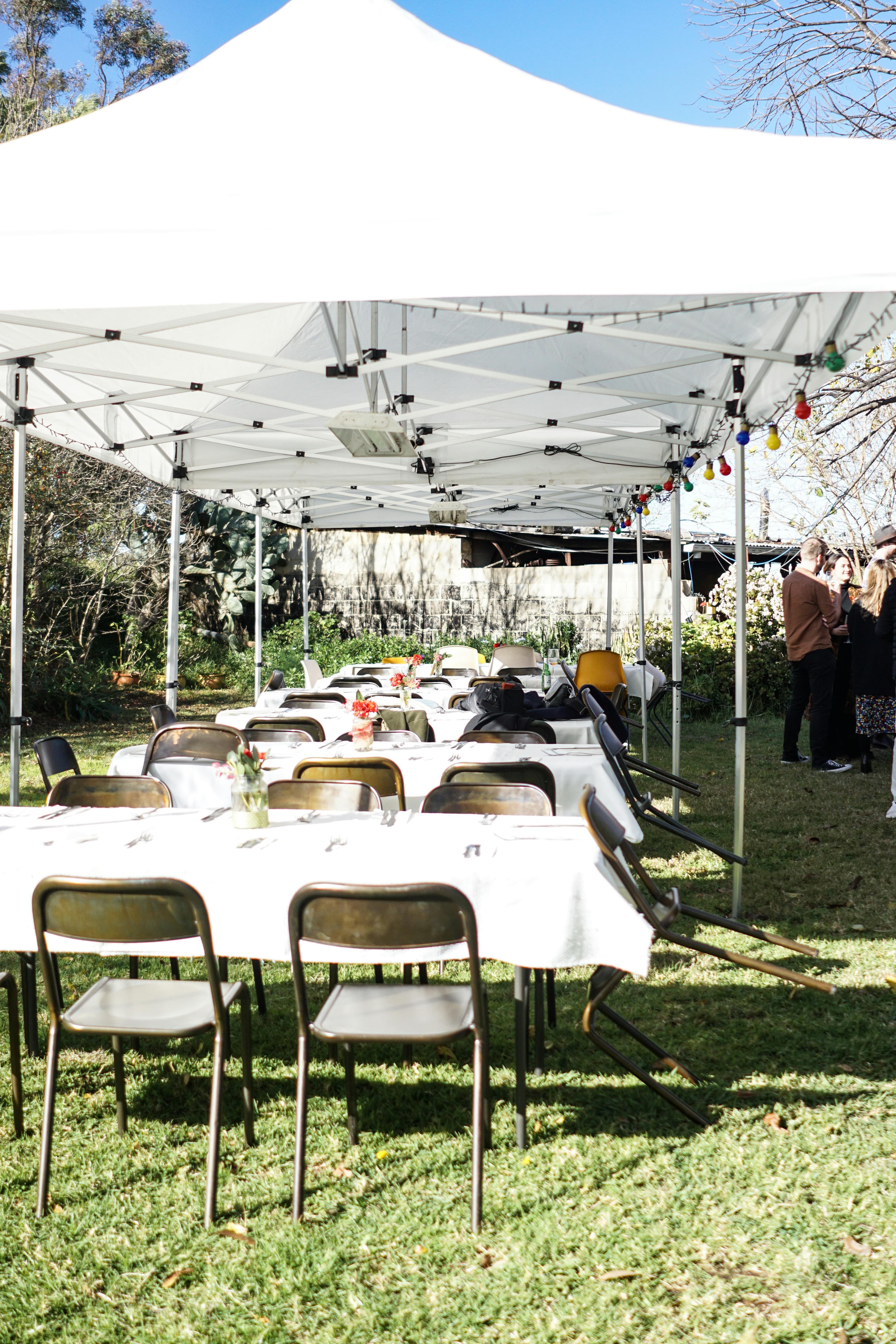Weddings - tables and chairs under a tent outside